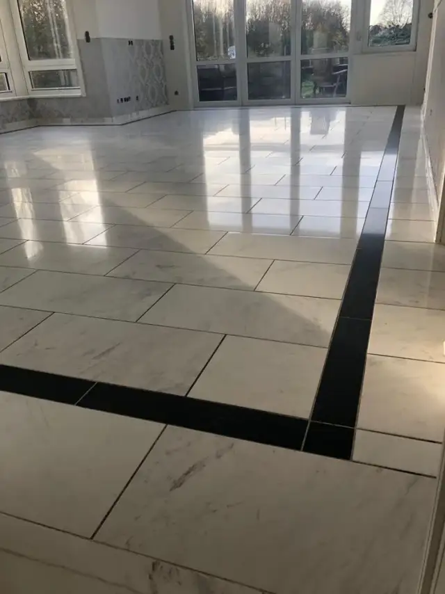 Gleichmäßig polierter Natursteinboden in einer großen Halle nach dem Schleifen und Polieren